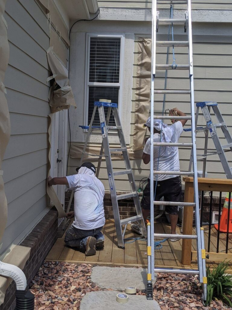 mi exterior painters hard at work in Brighton michigan doing professional top quality painting for this homes exterior